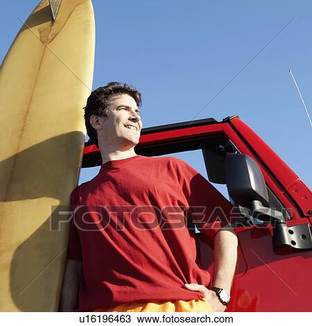 Low angle view of a mature man leaning against a sports utility vehicle with a surfboard View Large Photo Image Stock Image - Low angle view of a mature man leaning against a sports utility vehicle with a surfboard. Fotosearch