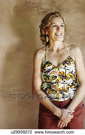 Stock Image - Mature woman smiling and looking away. Fotosearch