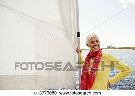 Mature woman standing in a sailboat and smiling View Large Photo Image Stock Image - Mature woman standing in a sailboat and smiling. Fotosearch