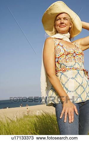 Mature woman standing on the beach and looking away View Large Photo Image Stock Image - Mature woman standing on the beach and looking away. Fotosearch