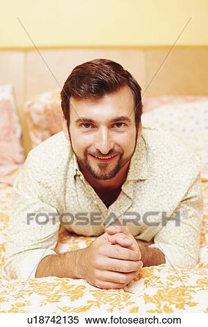 Portrait of a mature man lying on the bed and smiling View Large Photo Image Stock Photography - Portrait of a mature man lying on the bed and smiling. Fotosearch