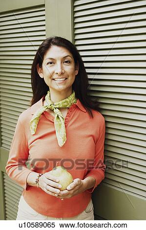 Portrait of a mature woman holding a pear View Large Photo Image Stock Photography - Portrait of a mature woman holding a pear. Fotosearch