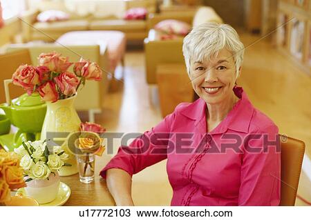 Stock Image - Portrait of a senior woman sitting and smiling. Fotosearch