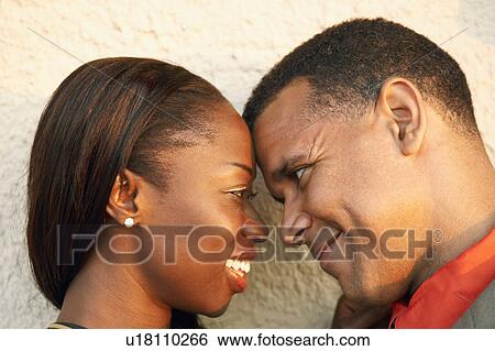 Stock Photograph - Close-up of a couple looking at each other and smiling. Fotosearch