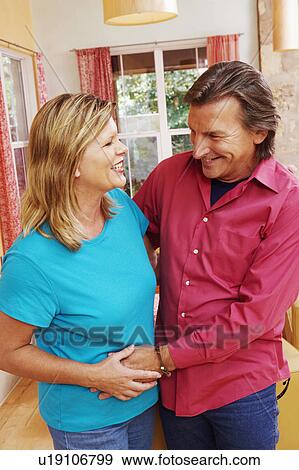 Stock Photo - Close-up of a mature couple embracing each other and smiling. Fotosearch