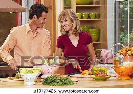 Mature couple cutting vegetables in the kitchen View Large Photo Image Stock Photography - Mature couple cutting vegetables in the kitchen. Fotosearch