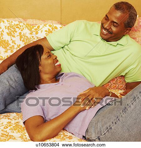 Mature couple lying on the bed and smiling View Large Photo Image Picture - Mature couple lying on the bed and smiling. Fotosearch