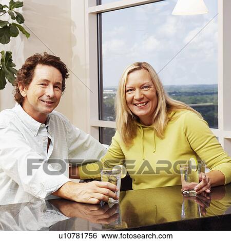 Portrait of a mature couple holding glasses of lemonade and smiling View Large Photo Image Stock Photograph - Portrait of a mature couple holding glasses of lemonade and smiling. Fotosearch