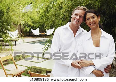 Portrait of a mature couple standing together and smiling View Large Photo Image Stock Photography - Portrait of a mature couple standing together and smiling. Fotosearch
