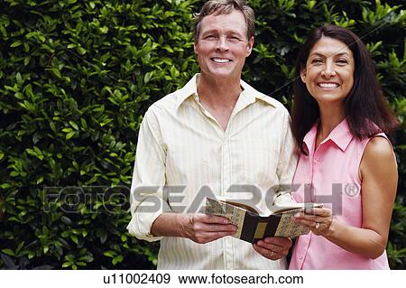 Portrait of a mature couple with a book in their hands standing together View Large Photo Image Stock Photo - Portrait of a mature couple with a book in their hands standing together. Fotosearch