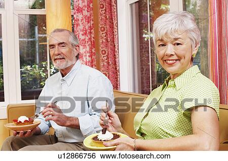 Portrait of a mature man and a senior woman eating a tart View Large Photo Image Stock Photograph - Portrait of a mature man and a senior woman eating a tart. Fotosearch