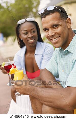 Portrait of a mature man holding a glass of juice with a mid adult woman holding a martini glass View Large Photo Image Stock Photography - Portrait of a mature man holding a glass of juice with a mid adult woman holding a martini glass. Fotosearch