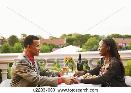 Side profile of a couple sitting at a table and smiling View Large Photo Image Stock Image - Side profile of a couple sitting at a table and smiling. Fotosearch
