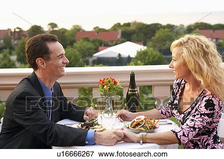 Side profile of a mature couple sitting at the table and smiling View Large Photo Image Stock Photo - Side profile of a mature couple sitting at the table and smiling. Fotosearch