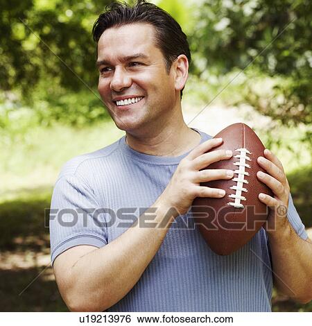 Close-up of a mature man holding a football View Large Photo Image Stock Photograph - Close-up of a mature man holding a football. Fotosearch