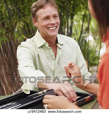 Stock Image - Close-up of a mature man playing backgammon with a mature woman. Fotosearch