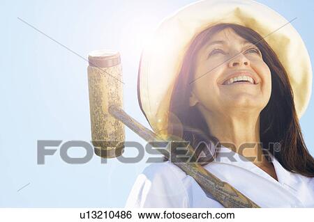 Stock Photograph - Low angle view of a mature woman holding a croquet mallet. Fotosearch