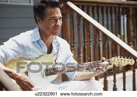 Mature man playing the guitar View Large Photo Image Stock Image - Mature man playing the guitar. Fotosearch