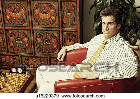 Portrait of a businessman sitting in an armchair View Large Photo Image Stock Photo - Portrait of a businessman sitting in an armchair. Fotosearch