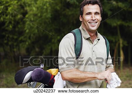 Portrait of a mature man carrying a golf bag View Large Photo Image Stock Photo - Portrait of a mature man carrying a golf bag. Fotosearch