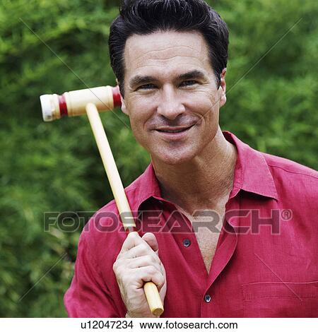 Portrait of a mature man holding a croquet mallet View Large Photo Image Picture - Portrait of a mature man holding a croquet mallet. Fotosearch