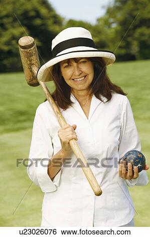 Portrait of a mature woman holding a croquet mallet and a ball View Large Photo Image Stock Photograph - Portrait of a mature woman holding a croquet mallet and a ball. Fotosearch