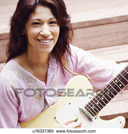 Portrait of a mature woman playing the guitar View Large Photo Image Stock Photography - Portrait of a mature woman playing the guitar. Fotosearch