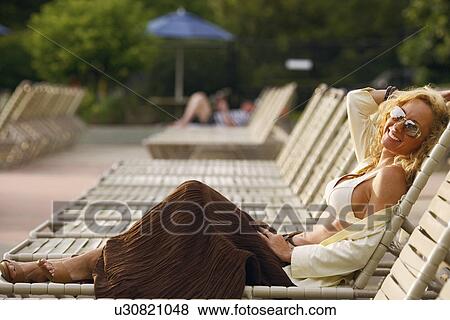 Side profile of a mature woman reclining on a lounge chair View Large Photo Image Stock Photo - Side profile of a mature woman reclining on a lounge chair. Fotosearch