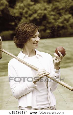 Close-up of a mid adult woman holding a croquet mallet and a ball View Large Photo Image Picture - Close-up of a mid adult woman holding a croquet mallet and a ball. Fotosearch