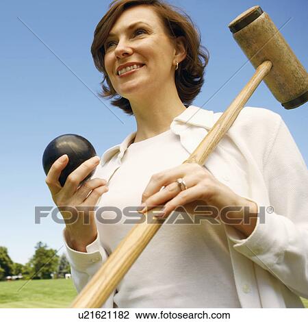 Close-up of a mid adult woman holding a croquet mallet and a ball View Large Photo Image Stock Image - Close-up of a mid adult woman holding a croquet mallet and a ball. Fotosearch