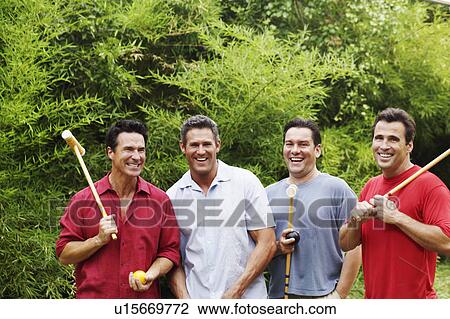 Mid adult man with three mature men holding croquet mallets and smiling View Large Photo Image Stock Image - Mid adult man with three mature men holding croquet mallets and smiling. Fotosearch