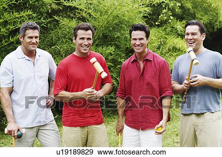 Mid adult man with three mature men standing and smiling View Large Photo Image Stock Photo - Mid adult man with three mature men standing and smiling. Fotosearch