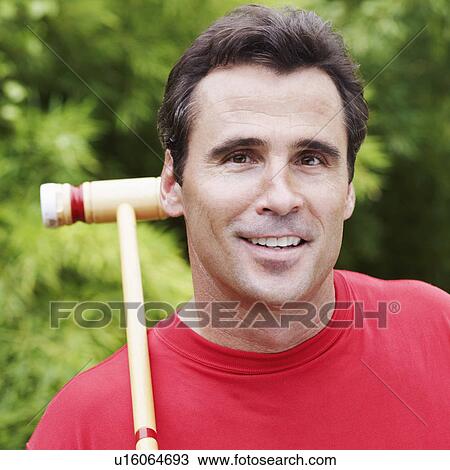 Stock Image - Portrait of a mature man with a croquet mallet. Fotosearch