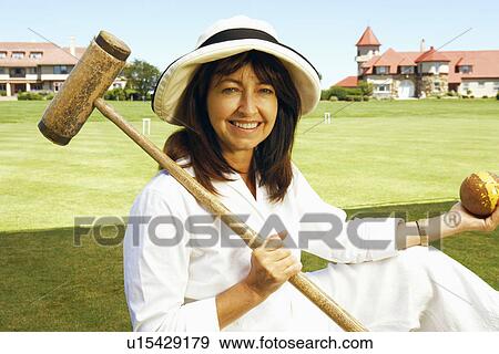 Portrait of a mature woman holding a croquet mallet and a ball View Large Photo Image Stock Photo - Portrait of a mature woman holding a croquet mallet and a ball. Fotosearch