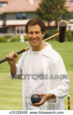 Portrait of a mid adult man holding a croquet mallet and a ball View Large Photo Image Stock Photography - Portrait of a mid adult man holding a croquet mallet and a ball. Fotosearch
