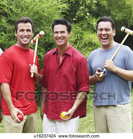 Picture - Portrait of three mature men standing together and smiling. Fotosearch