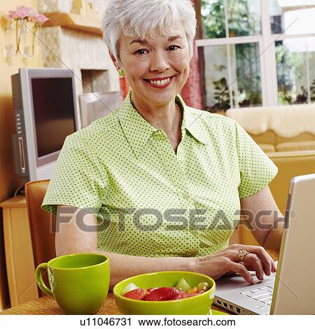 Portrait of a senior woman using a laptop and smiling View Large Photo Image Stock Image - Portrait of a senior woman using a laptop and smiling. Fotosearch