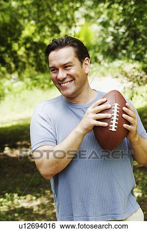 Close-up of a mature man holding a football View Large Photo Image Stock Photograph - Close-up of a mature man holding a football. Fotosearch
