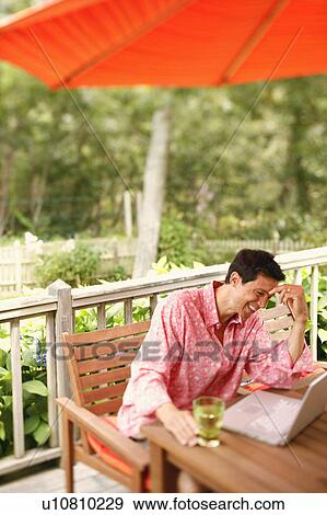 Mature man sitting in front of a laptop View Large Photo Image Stock Photo - Mature man sitting in front of a laptop. Fotosearch