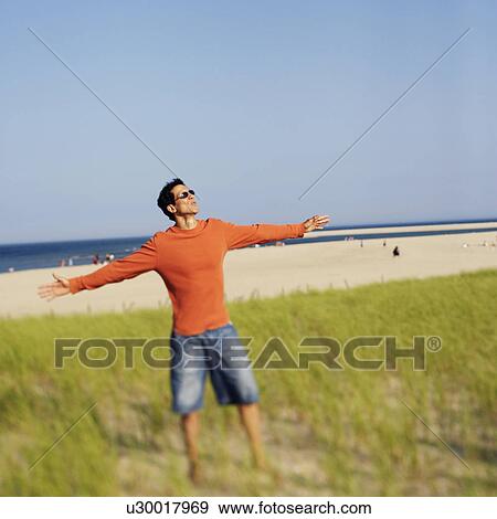 Mature man standing on the beach with his arms outstretched View Large Photo Image Stock Photo - Mature man standing on the beach with his arms outstretched. Fotosearch