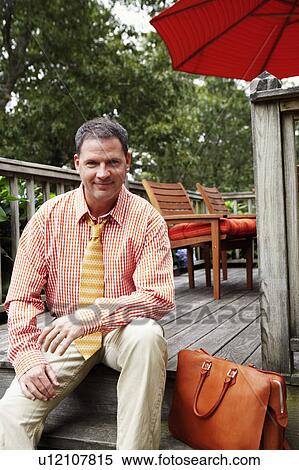 Stock Photography - Portrait of a businessman sitting and smiling. Fotosearch