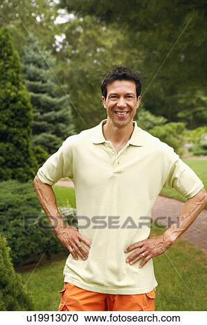 Stock Image - Portrait of a mature man smiling in a park. Fotosearch