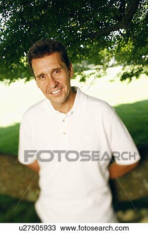 Stock Image - Portrait of a mature man with his hands behind his back. Fotosearch