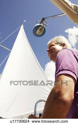 Picture - Side profile of a mature man smiling in a sailboat. Fotosearch
