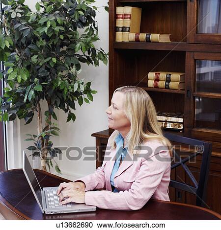 Businesswoman working on a laptop View Large Photo Image Stock Image - Businesswoman working on a laptop. Fotosearch