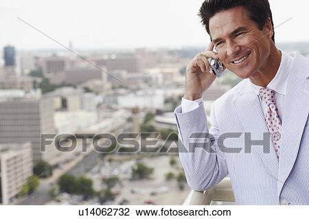 Close-up of a businessman talking on a mobile phone View Large Photo Image Stock Image - Close-up of a businessman talking on a mobile phone. Fotosearch
