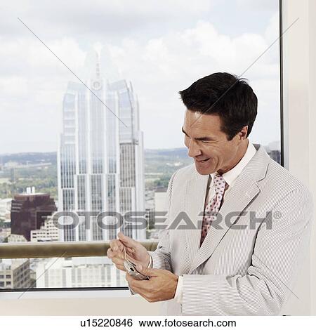 Stock Photograph - Close-up of a businessman using a personal data assistant. Fotosearch