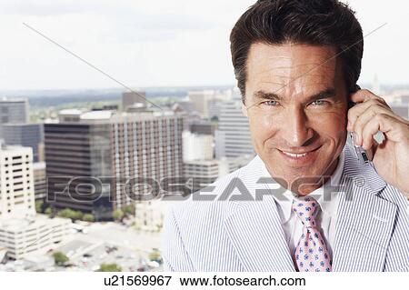 Stock Photo - Portrait of a businessman talking on a mobile phone. Fotosearch