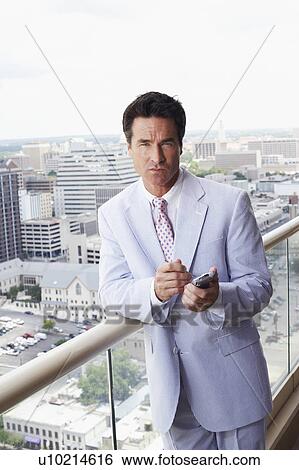 Portrait of a businessman using a personal data assistant View Large Photo Image Stock Photograph - Portrait of a businessman using a personal data assistant. Fotosearch
