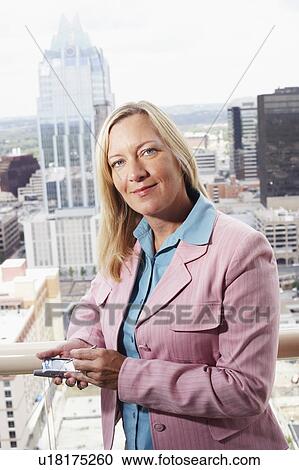 Stock Image - Portrait of a businesswoman using a personal data assistant. Fotosearch